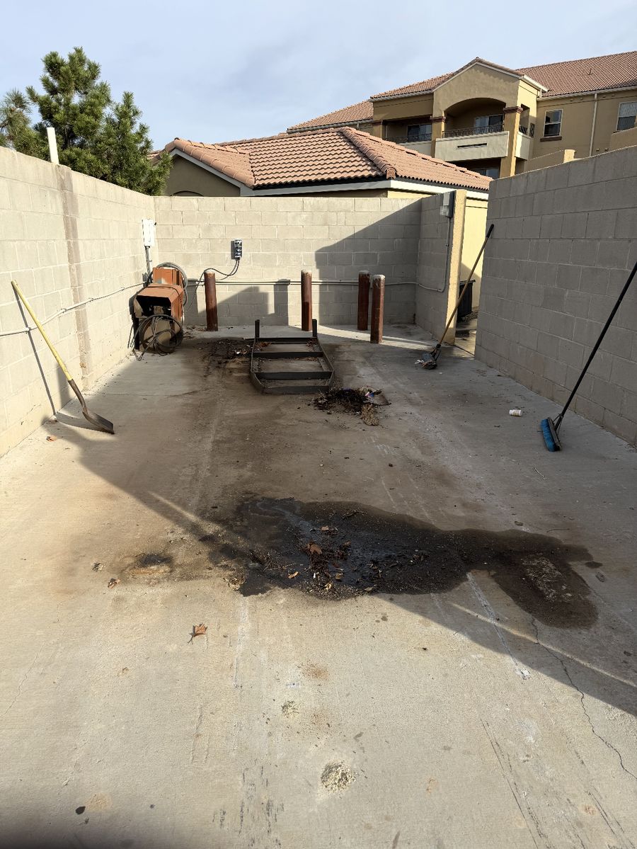 Dumpster pad concrete stained with oil and grease before pressure washing