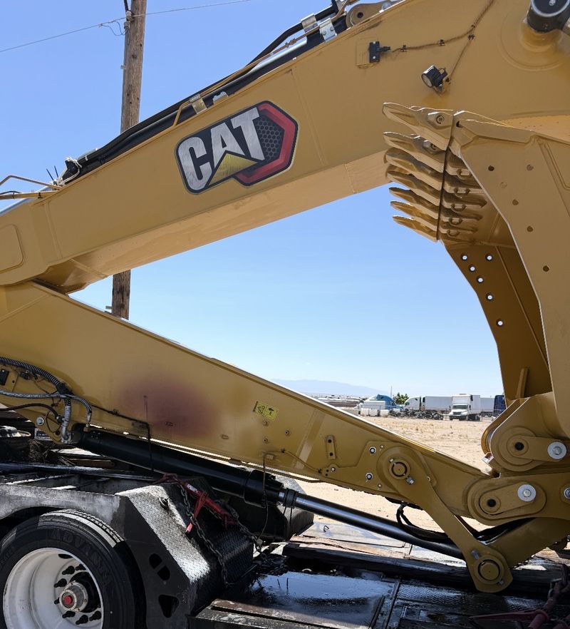 Same excavator arm cleaned, with the CAT logo and yellow paint restored